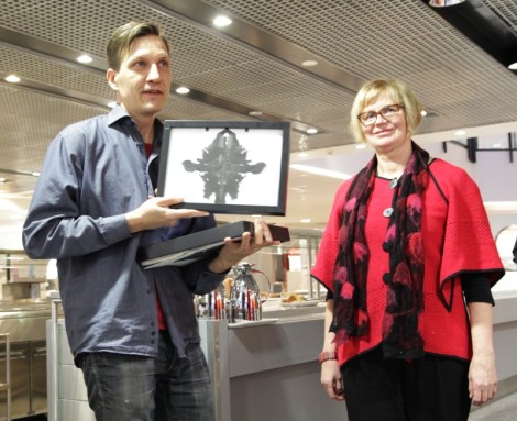 Maija Ferchen sai kuvataideopettaja Juha Rantaselta mustetahratestitauluja. Kuva: Heli Toivonen.